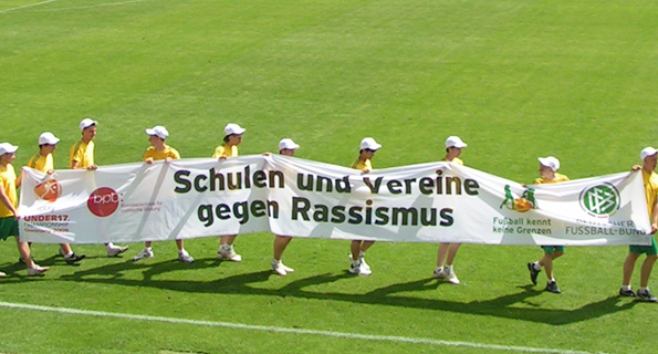 Kinder tragen Aktionsbanner ins Stadion