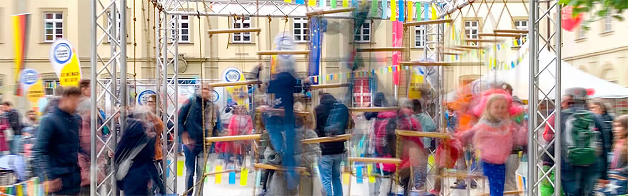 Illustratives Startbild mit Kindern und Eltern im Erlebnisland von „Kinder stark machen“